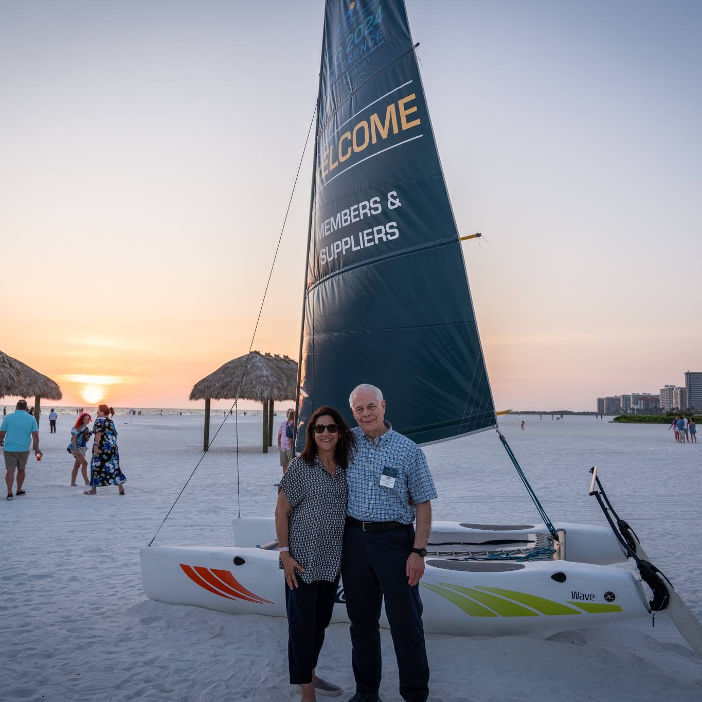 man and woman posed in front of welcome banner