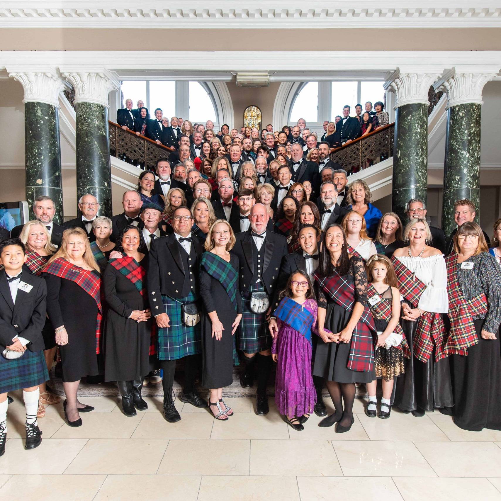 large group photo in front of a grand staircase
